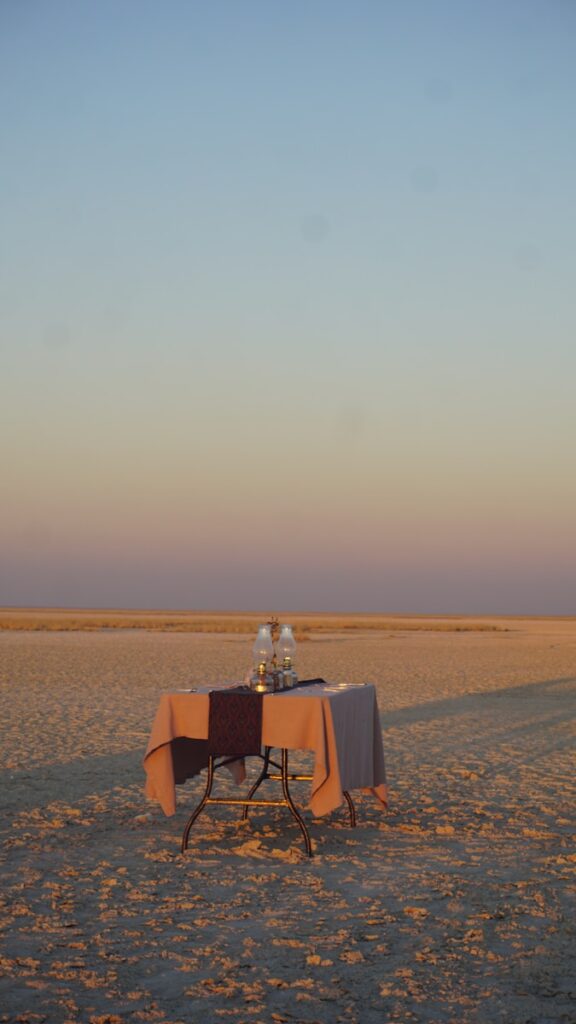 A table set for two in a vast, empty landscape.